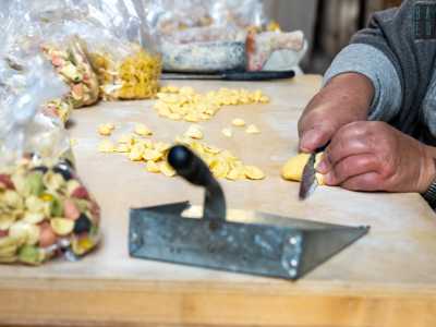 Vediamo la donna prendere un panetto di massa dato dall�impasto di semola di grano duro e acqua...